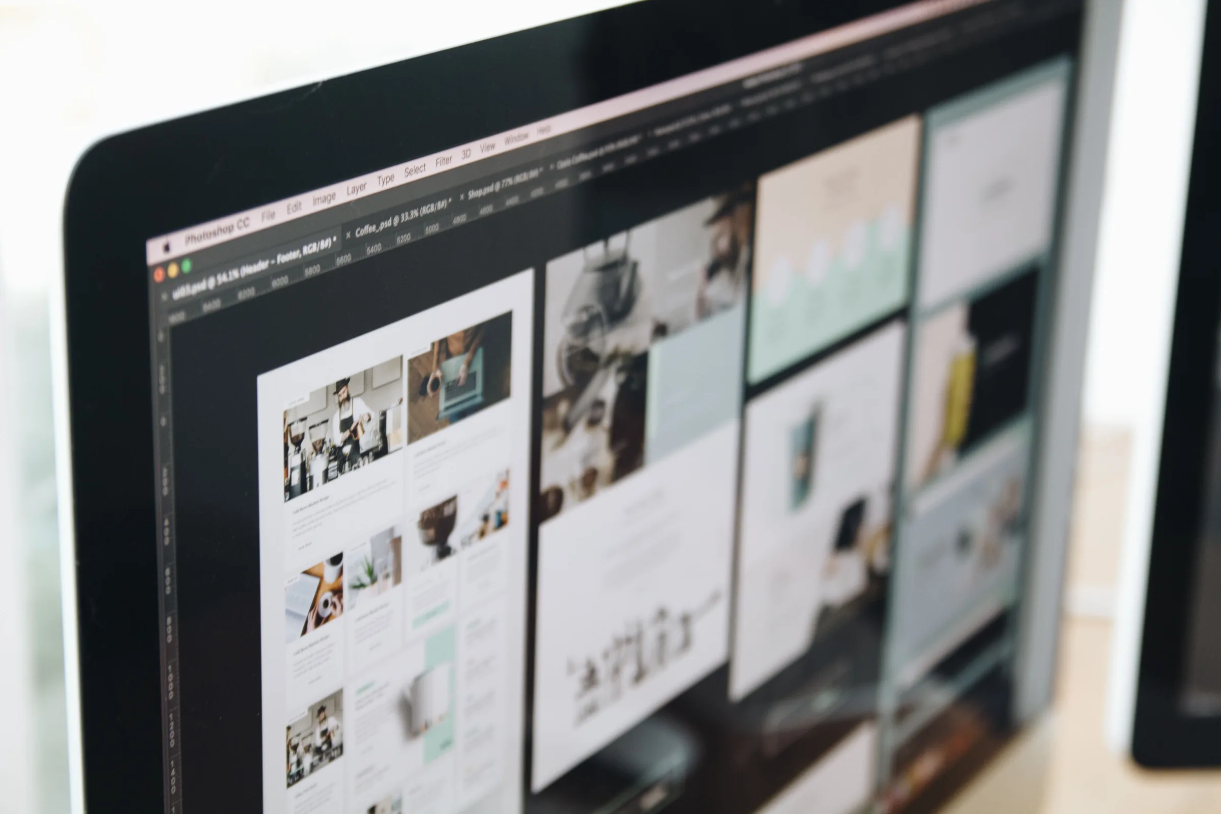 Computer monitor displaying Photoshop with multiple image files and design projects open.